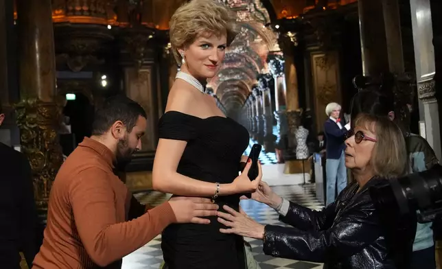 Grevin Museum employees set the life-size wax figure of Lady Diana presented at Grevin Museum in Paris, France, Thursday, Nov. 20, 2025. (AP Photo/Christophe Ena)