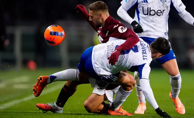 Torino's Nikola Vlasic fights for the ball with Como's Alex Valle during the Serie A soccer match between Torino and Como, in Turin, Italy, Monday, Nov. 24, 2025. (Fabio Ferrari/LaPresse via AP)