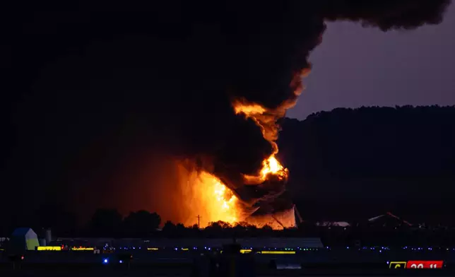 A fireball erupts near airport property after reports of a plane crash at Louisville International Airport, Tuesday, Nov. 4, 2025, in Louisville, Ky. (AP Photo/Jon Cherry)