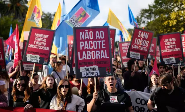 A demonstrator carrying a poster with the words "No to the labour package" shouts slogans during a national protest by workers unions against a new labour package being prepared by the government, in Lisbon, Saturday, Nov. 8, 2025. (AP Photo/Armando Franca)