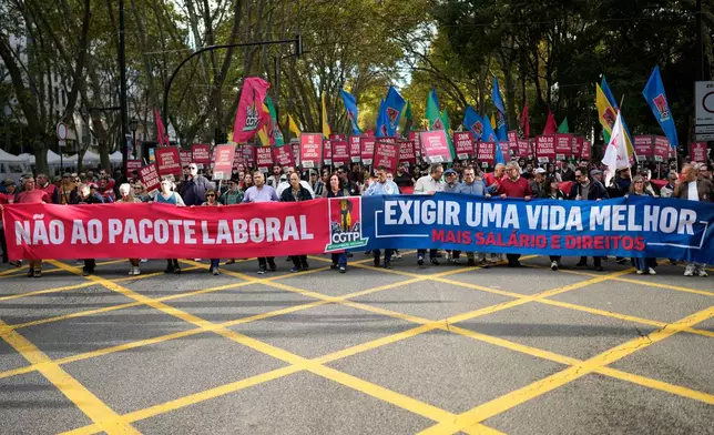 Demonstrators carry banners read "No to the labour package" and "Demand a better life" during a national protest by workers unions against a new labour package being prepared by the government in Lisbon, Portugal, Saturday, Nov. 8, 2025. (AP Photo/Armando Franca)