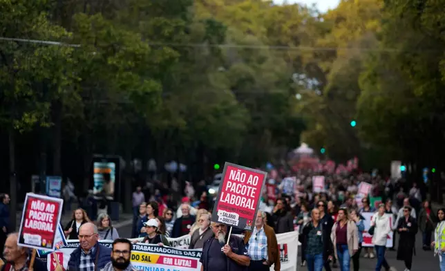 Demonstrators carrying posters read "No to the labour package" march down Liberdade Avenue during a national protest by workers unions against a new labour package being prepared by the government in Lisbon, Portugal, Saturday, Nov. 8, 2025. (AP Photo/Armando Franca)