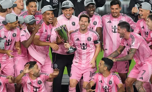 Inter Miami forward Lionel Messi (10) holds the trophy as Inter Miami players celebrate winning an MLS Eastern Conference final soccer match against New York City FC, Saturday, Nov. 29, 2025, in Fort Lauderdale, Fla. (AP Photo/Rebecca Blackwell)