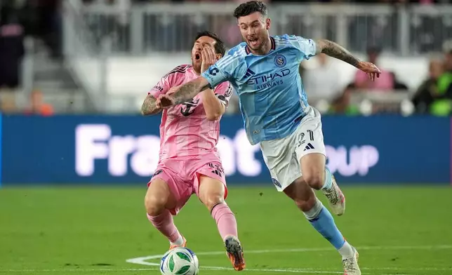 Inter Miami forward Lionel Messi, left, goes down in a clash with New York City FC midfielder Aiden O'Neill (21) during the first half of an MLS Eastern Conference final soccer match, Saturday, Nov. 29, 2025, in Fort Lauderdale, Fla. (AP Photo/Rebecca Blackwell)