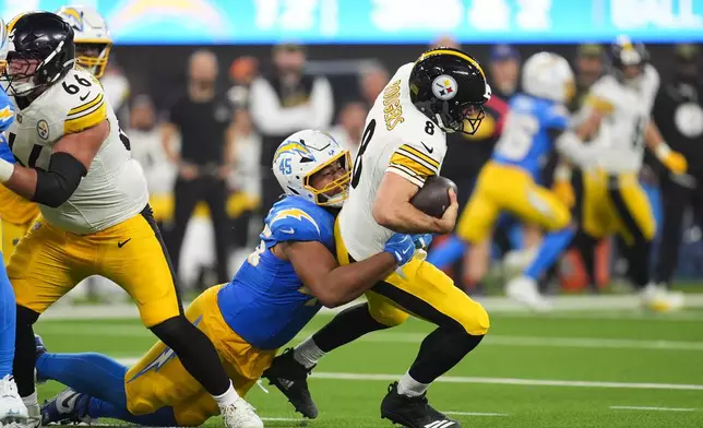 Pittsburgh Steelers quarterback Aaron Rodgers (8) is sacked by Los Angeles Chargers linebacker Tuli Tuipulotu (45) during the second half of an NFL football game Sunday, Nov. 9, 2025, in Inglewood, Calif. (AP Photo/Marcio Jose Sanchez)