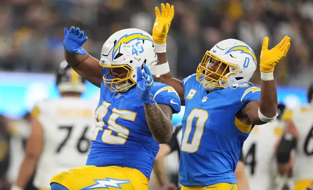 Los Angeles Chargers linebacker Tuli Tuipulotu (45) celebrates his sack with linebacker Daiyan Henley (0) during the second half of an NFL football against the Pittsburgh Steelers game Sunday, Nov. 9, 2025, in Inglewood, Calif. (AP Photo/Marcio Jose Sanchez)