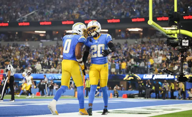 Los Angeles Chargers cornerback Cam Hart (20) and linebacker Daiyan Henley (0) celebrate after breaking up a touchdown pass during the second half of an NFL football game against the Pittsburgh Steelers Sunday, Nov. 9, 2025, in Inglewood, Calif. (AP Photo/Jessie Alcheh)
