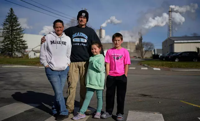 Gerard Berry with his wife Stephanie, and children Brooklynn and Aidan, pose near the Woodland Pulp mill, Friday, Nov. 7, 2025, during a walk in their neighborhood in Baileyville, Maine. (AP Photo/Robert F. Bukaty)