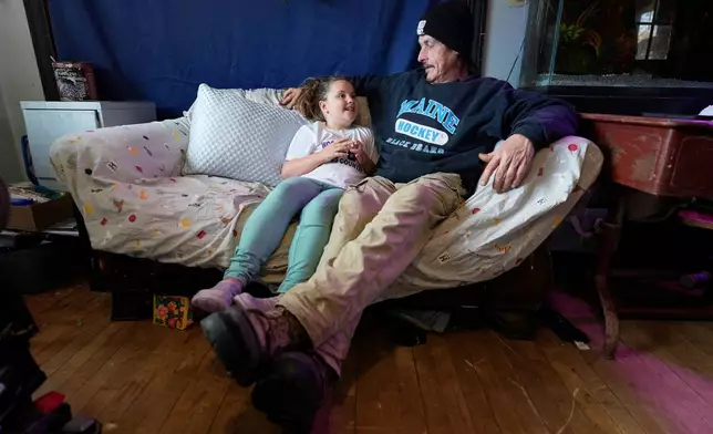 Gerard Berry talks with his daughter Brooklynn about her schoolwork, Friday, Nov. 7, 2025, in Baileyville, Maine. (AP Photo/Robert F. Bukaty)