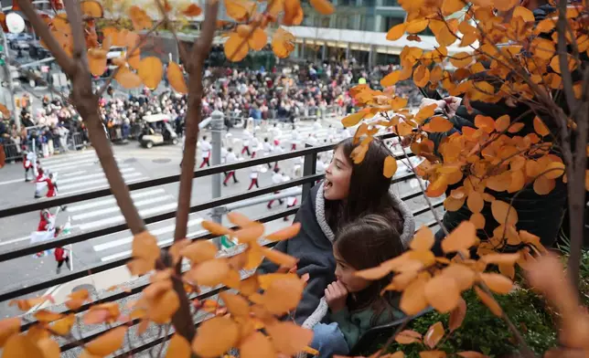 Spectators watch the Macy's Thanksgiving Day Parade as it marches down Sixth Avenue, Thursday, Nov. 27, 2025, in New York. (AP Photo/Heather Khalifa)