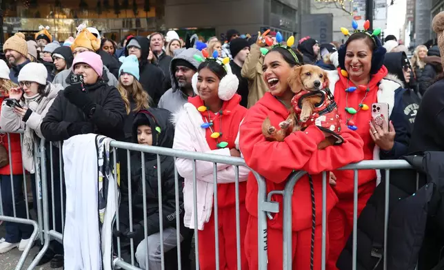 Spectators watch as the Macy's Thanksgiving Day Parade passes them, Thursday, Nov. 27, 2025, in New York. (AP Photo/Heather Khalifa)