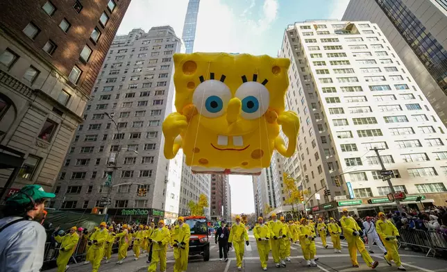 Balloon handlers guid the Sponge Bob Square Pants balloon down Sixth Avenue during the Macy's Thanksgiving Day Parade, Thursday, Nov. 27, 2025, in New York. (AP Photo/Eduardo Munoz Alvarez)
