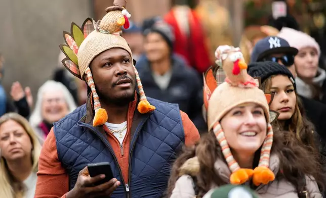 Spectators watch as balloons and floats pass on Sixth Avenue during the Macy's Thanksgiving Day Parade, Thursday, Nov. 27, 2025, in New York. (AP Photo/Eduardo Munoz Alvarez)
