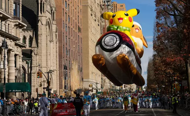 Balloon handlers guide the Pikachu &amp; Eevee balloon down Central Park West during the Macy's Thanksgiving Day Parade, Thursday, Nov. 27, 2025, in New York. (AP Photo/Frank Franklin)