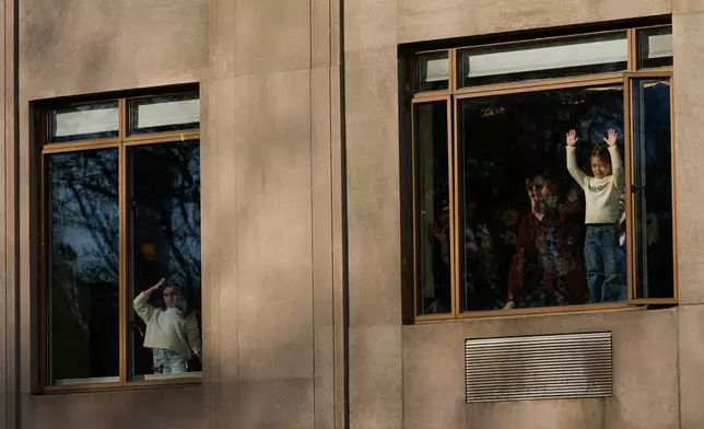 Spectators watch from their apartment windows as the Macy's Thanksgiving Day Parade passes by on Central Park West, Thursday, Nov. 27, 2025, in New York. (AP Photo/Frank Franklin)