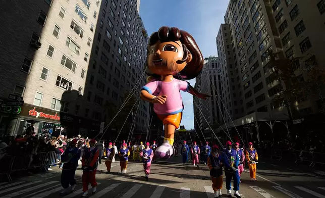 Balloon handlers guide the Dora balloon down Sixth Avenue during the Macy's Thanksgiving Day Parade, Thursday, Nov. 27, 2025, in New York. (AP Photo/Eduardo Munoz Alvarez)