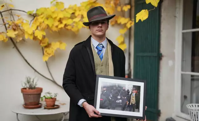 Pedro Elias Garzon Delvaux poses with an Associated Press photo of him outside the Louvre on the day of the crown jewels heist, Saturday, Nov. 8, 2025, in Rambouillet, south of Paris. (AP Photo/Thibault Camus)