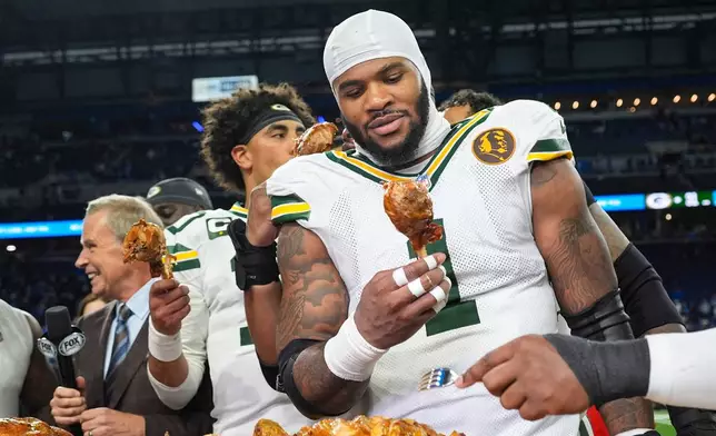 Green Bay Packers defensive lineman Micah Parsons (1) grabs a turkey leg following an NFL football game against the Detroit Lions in Detroit, Thursday, Nov. 27, 2025. (AP Photo/Ryan Sun)