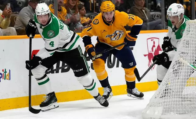Dallas Stars defenseman Miro Heiskanen (4) clears the puck away from Nashville Predators right wing Matthew Wood (71) during the second period of an NHL hockey game Saturday, Nov. 8, 2025, in Nashville, Tenn. (AP Photo/Mark Humphrey)