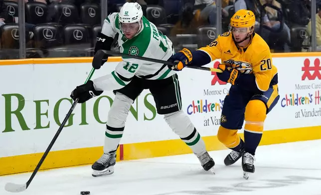 Nashville Predators defenseman Justin Barron (20) tries to slow down Dallas Stars center Radek Faksa (12) during the first period of an NHL hockey game Saturday, Nov. 8, 2025, in Nashville, Tenn. (AP Photo/Mark Humphrey)