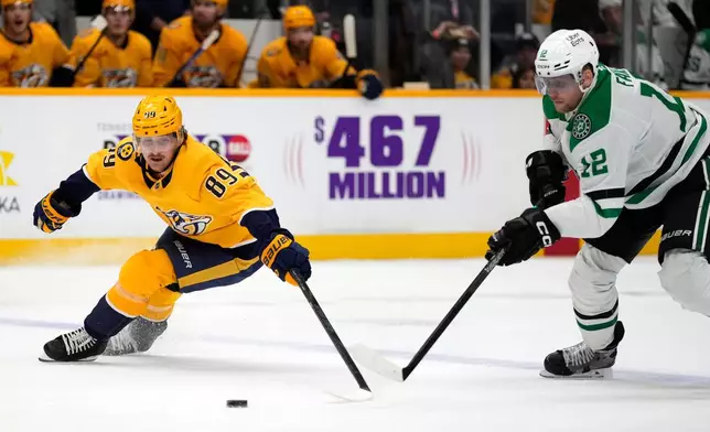 Nashville Predators right wing Ozzy Wiesblatt (89) chases the puck with Dallas Stars center Radek Faksa (12) during the second period of an NHL hockey game Saturday, Nov. 8, 2025, in Nashville, Tenn. (AP Photo/Mark Humphrey)