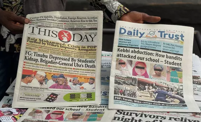 A vendor display local newspapers on the street of Lagos with headlines of the Government Girls Comprehensive Secondary School, where gunmen on Monday attacked the school dormitory, abducted schoolgirls, in Kebbi Nigeria, Wednesday, Nov. 19 2025. (AP Photo/Sunday Alamba )