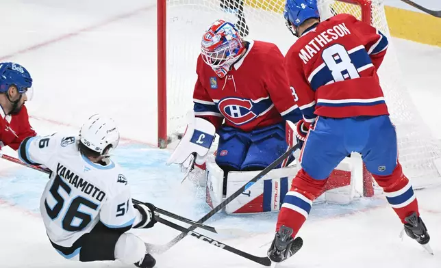 Utah Mammoth's Kailer Yamamoto (56) scores against Montreal Canadiens goaltender Sam Montembeault as Canadiens' Mike Matheson (8) defends during first period NHL hockey action in Montreal, Saturday, Nov. 8, 2025. (Graham Hughes/The Canadian Press via AP)