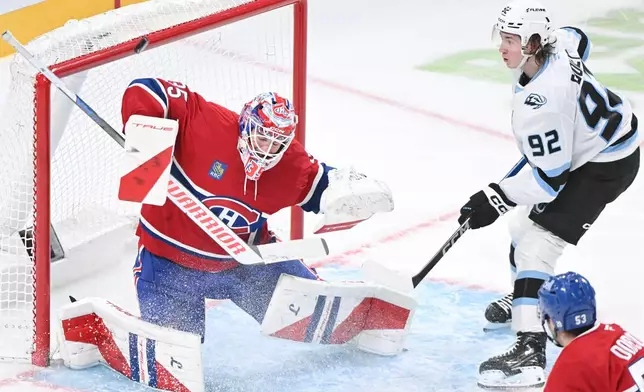 Utah Mammoth's Logan Cooley (92) moves in on Montreal Canadiens goaltender Sam Montembeault during second period NHL hockey action in Montreal, Saturday, Nov. 8, 2025. (Graham Hughes/The Canadian Press via AP)