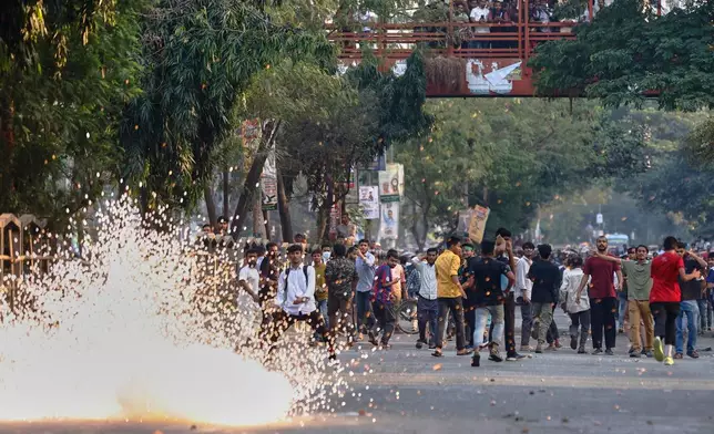 Police use stun grenades to disperse protesters gathering outside the demolished residence of Sheikh Mujibur Rahman, Bangladesh's former leader and the father of the country's ousted Prime Minister Sheikh Hasina following the verdict against her, in Dhaka, Bangladesh, Monday, Nov. 17, 2025. (AP Photo/ Rajib Dhar)