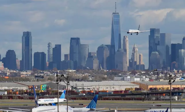 The New York City skyline is seen behind a plane approaching Newark International Airport in Newark, N.J., Thursday, Nov. 6, 2025. (AP Photo/Seth Wenig)