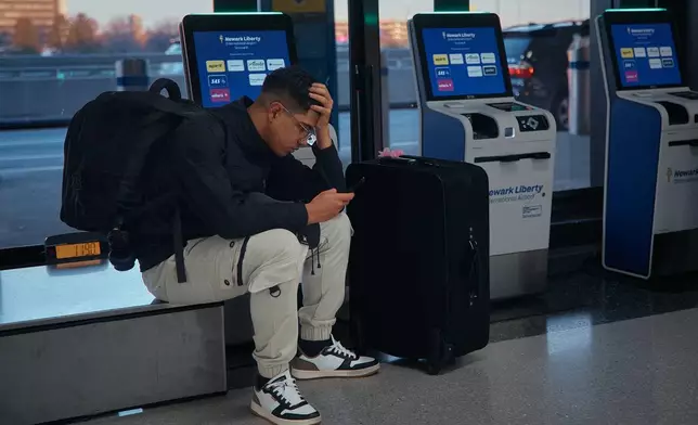 A passenger flying with Arajet to Santo Domingo waits to check in at Newark Liberty International Airport on Friday, Nov. 7, 2025 in Newark, N.J. (AP Photo/Andres Kudacki)
