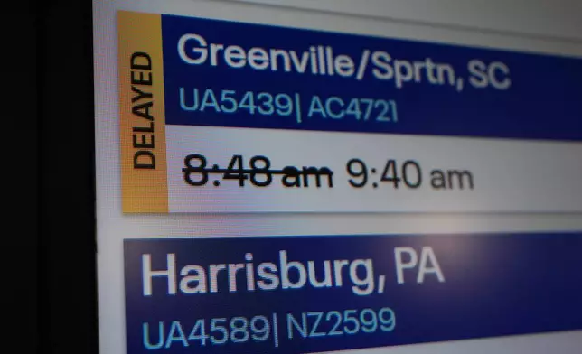 An information sign displays a delayed flight at O'Hare International Airport in Chicago, Friday, Nov. 7, 2025. (AP Photo/Nam Y. Huh)