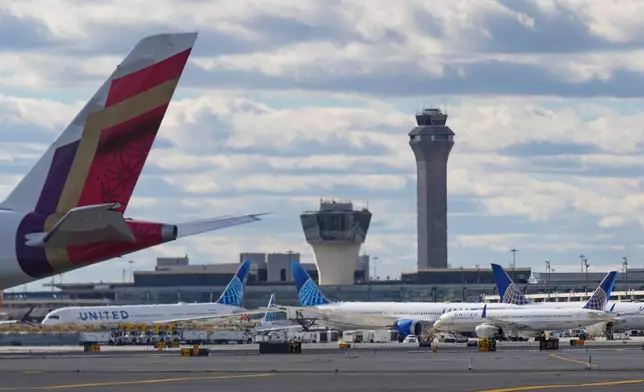 Planes taxi in front of an air traffic control tower at Newark International Airport in Newark, N.J., Thursday, Nov. 6, 2025. (AP Photo/Seth Wenig)