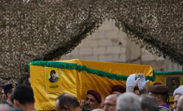 Hezbollah fighters carry the coffin of Hezbollah's Chief of Staff Haytham Tabtabai who was killed with other Hezbollah fighters in Sunday's Israeli airstrike, during his funeral procession in the southern suburb of Beirut, Lebanon, Monday, Nov. 24, 2025. (AP Photo/Hussein Malla)