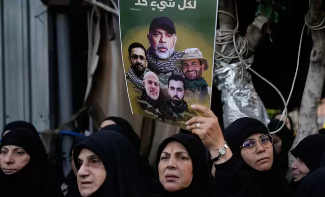 Hezbollah supporters hold portraits of Hezbollah's Chief of Staff Haytham Tabtabai and other fighters who were killed in Sunday's Israeli airstrike during their funeral procession in the southern suburb of Beirut, Lebanon, Monday, Nov. 24, 2025. The Arabic words on the portraits read: "Everything has a limit." (AP Photo/Hussein Malla)
