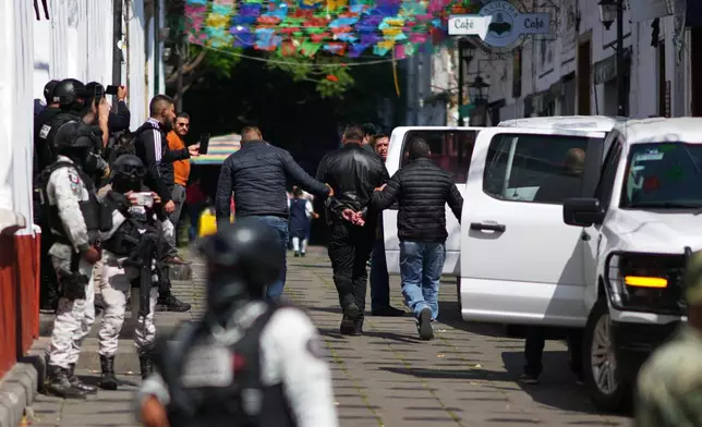 Michoacan state prosecutor officers detain a suspect in the killing of Mayor Carlos Manzo Rodriguez in Uruapan, Mexico, Friday, Nov. 21, 2025. (AP Photo/Eduardo Verdugo)