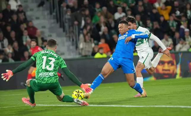 Real Madrid's Kylian Mbappe, centre, tries to score past Elche's goalkeeper Inaki Pena during the Spanish La Liga soccer match between Elche and Real Madrid in Elche, Spain, Sunday, Nov. 23, 2025. (AP Photo/Alberto Saiz)
