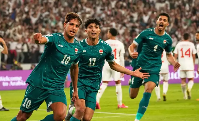 Iraqi's Mohanad Ali, left, celebrates with teammates after scoring his side's first goal during the 2026 World Cup play off second leg match between Iraq and UAE, in Basra, Iraq, Tuesday, Nov. 18, 2025. (AP Photo/Hadi Mizban)
