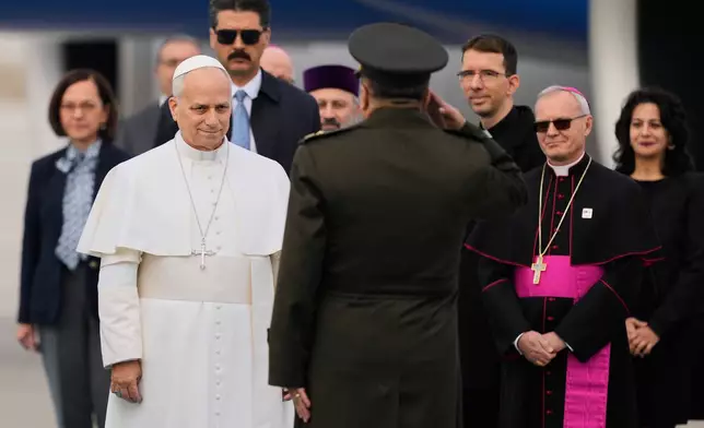 Pope Leo XIV is welcomed upon his arrival at Esenboga International Airport in Ankara, Turkey, Thursday, Nov. 27, 2025, marking the beginning of his first foreign trip. (AP Photo/Khalil Hamra)