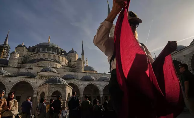Locals and tourists visit the Ottoman-era Sultan Ahmed or Blue Mosque, in Istanbul, Turkey, Friday, Nov. 21, 2025, ahead of the visit of Pope Leo XIV to Turkey. (AP Photo/Francisco Seco)