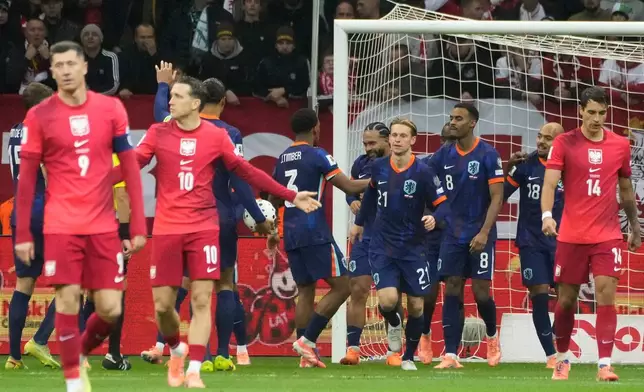 The Netherlands players, background, celebrate after Memphis Depay, center, scored their first goal during a World Cup 2026 group G qualifying soccer match between Poland and the Netherlands in Warsaw, Friday, Nov. 14, 2025. (AP Photo/Czarek Sokolowski)