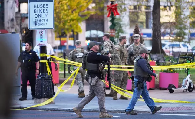 U.S. Marshalls and National Guard troops are seen after reports of two National Guard soldiers shot near the White House in Washington, Wednesday, Nov. 26, 2025. (AP Photo/Evan Vucci)