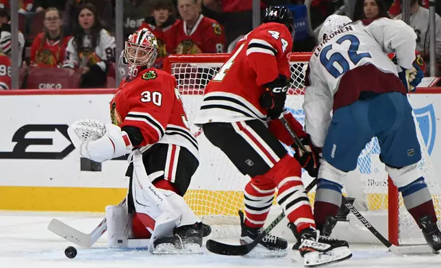 Chicago Blackhawks goalie Spencer Knight (30) makes a save during the first period of an NHL hockey game against the Colorado Avalanche, Sunday, Nov. 23, 2025, in Chicago. (AP Photo/Paul Beaty)
