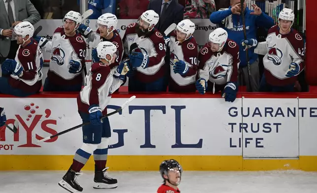 Colorado Avalanche's Cale Makar celebrates with teammates at the bench after scoring a goal during the second period of an NHL hockey game against the Chicago Blackhawks, Sunday, Nov. 23, 2025, in Chicago. (AP Photo/Paul Beaty)