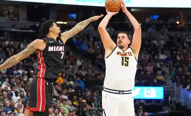 Denver Nuggets center Nikola Jokic, right, shoots for a basket as Miami Heat center Kel'el Ware defends in the second half of an NBA basketball game Wednesday, Nov. 5, 2025, in Denver. (AP Photo/David Zalubowski)