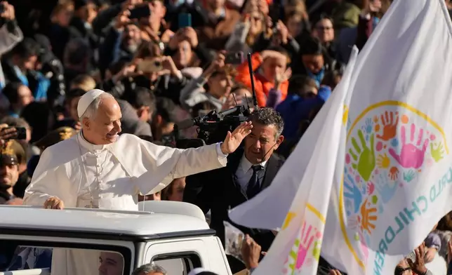Pope Leo XIV waves to faithful as he arrives in St. Peter's Square on the occasion of the weekly general audience at the Vatican, Wednesday, Nov. 19, 2025. (AP Photo/Gregorio Borgia)