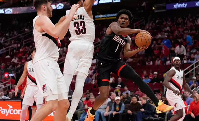 Houston Rockets guard Amen Thompson (1) passes against Portland Trail Blazers forward Toumani Camara (33) during the second half of an NBA Cup basketball game in Houston, Friday, Nov. 14, 2025. (AP Photo/Ashley Landis)