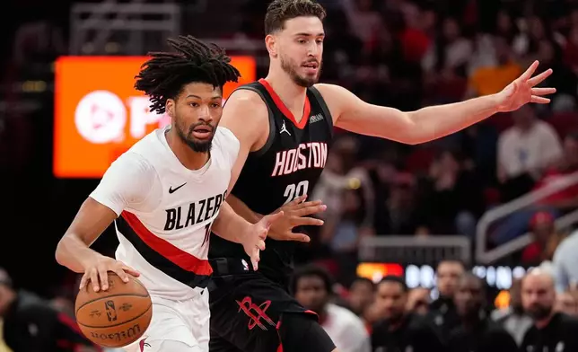 Houston Rockets center Alperen Sengun (28) defends against Portland Trail Blazers guard Shaedon Sharpe, left, during the first half of an NBA Cup basketball game in Houston, Friday, Nov. 14, 2025. (AP Photo/Ashley Landis)