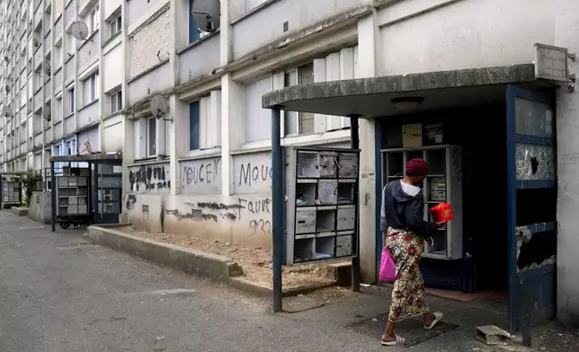 FILE - A woman goes home with a meal distributed by 'Laissez Les Servir' (Let Them Serve) in the Fauvettes projects, Pierrefitte-sur-Seine, north of Paris, Thursday, April 29, 2021. (AP Photo/Thibault Camus, File)