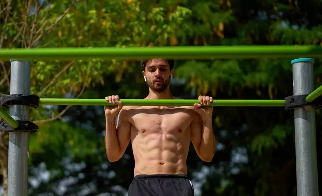 FILE - A man works out in a public park in Madrid, Spain on July 1, 2025. (AP Photo/Manu Fernandez, File)